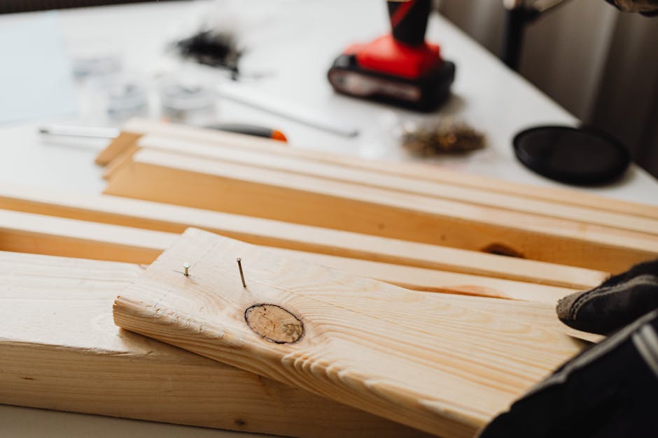 Close-up of woodworking, showing a power drill and wooden planks for DIY projects.