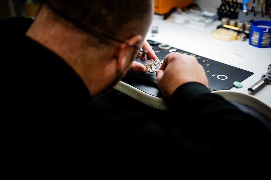 A watchmaker carefully repairs a wristwatch in a workshop setting, highlighting precision and skill.
